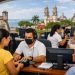 Personas en un módulo de gobierno en Campeche capturando datos biométricos con arquitectura colonial de fondo