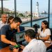 Hombre registrando su huella digital para la CURP biométrica en Veracruz, con el faro y el malecón del puerto visibles a través de la ventana